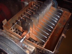 A box-shaped machine with many metal slots, used for pressing apples